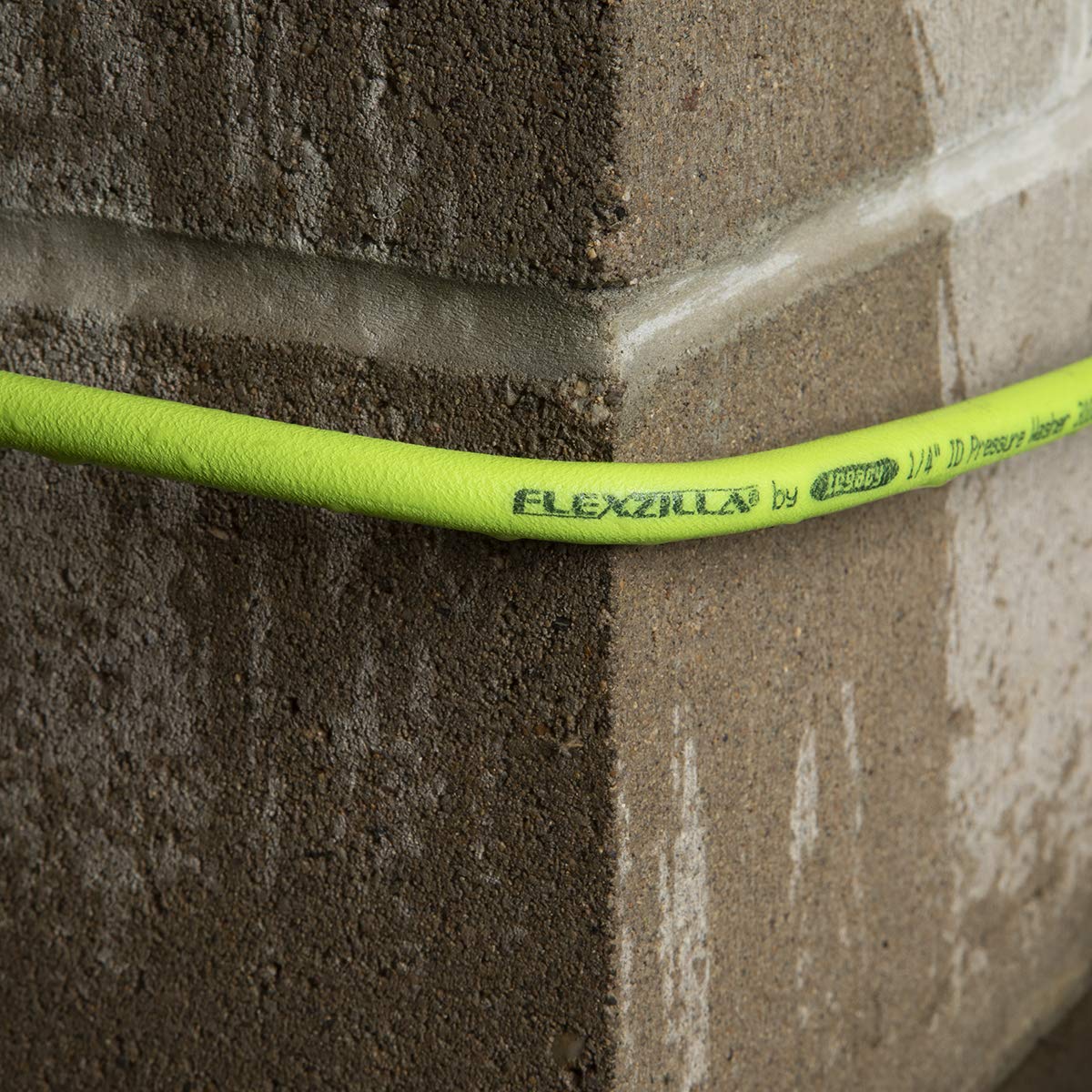 Flexzilla 50 ft hose coiled next to a foot for scale showing extended reach