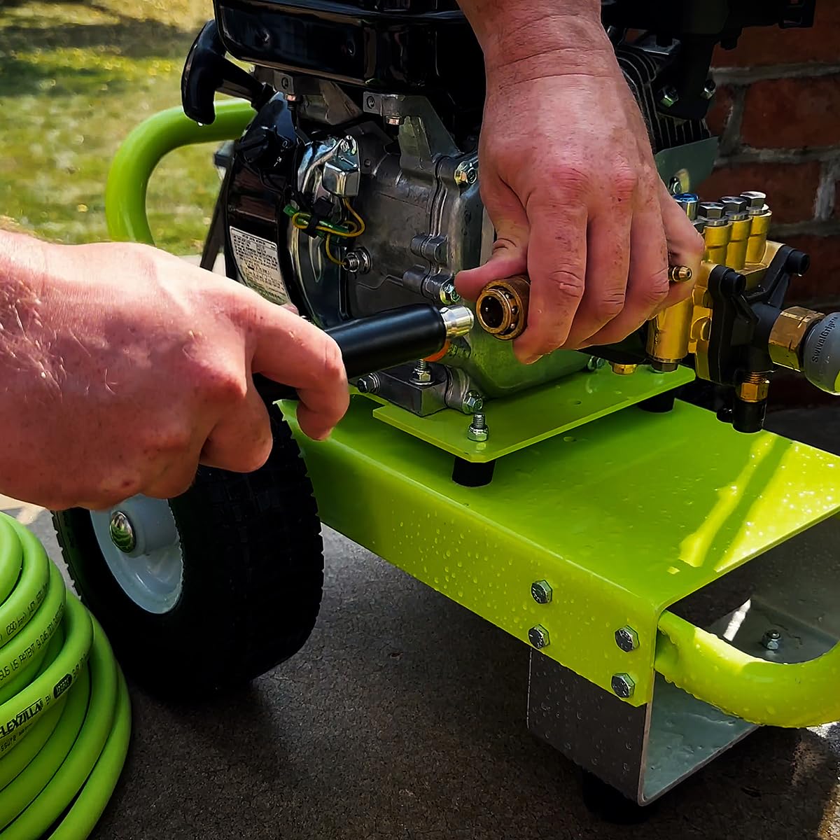 Flexzilla 50ft hose coiled beside yard tools showing length scale