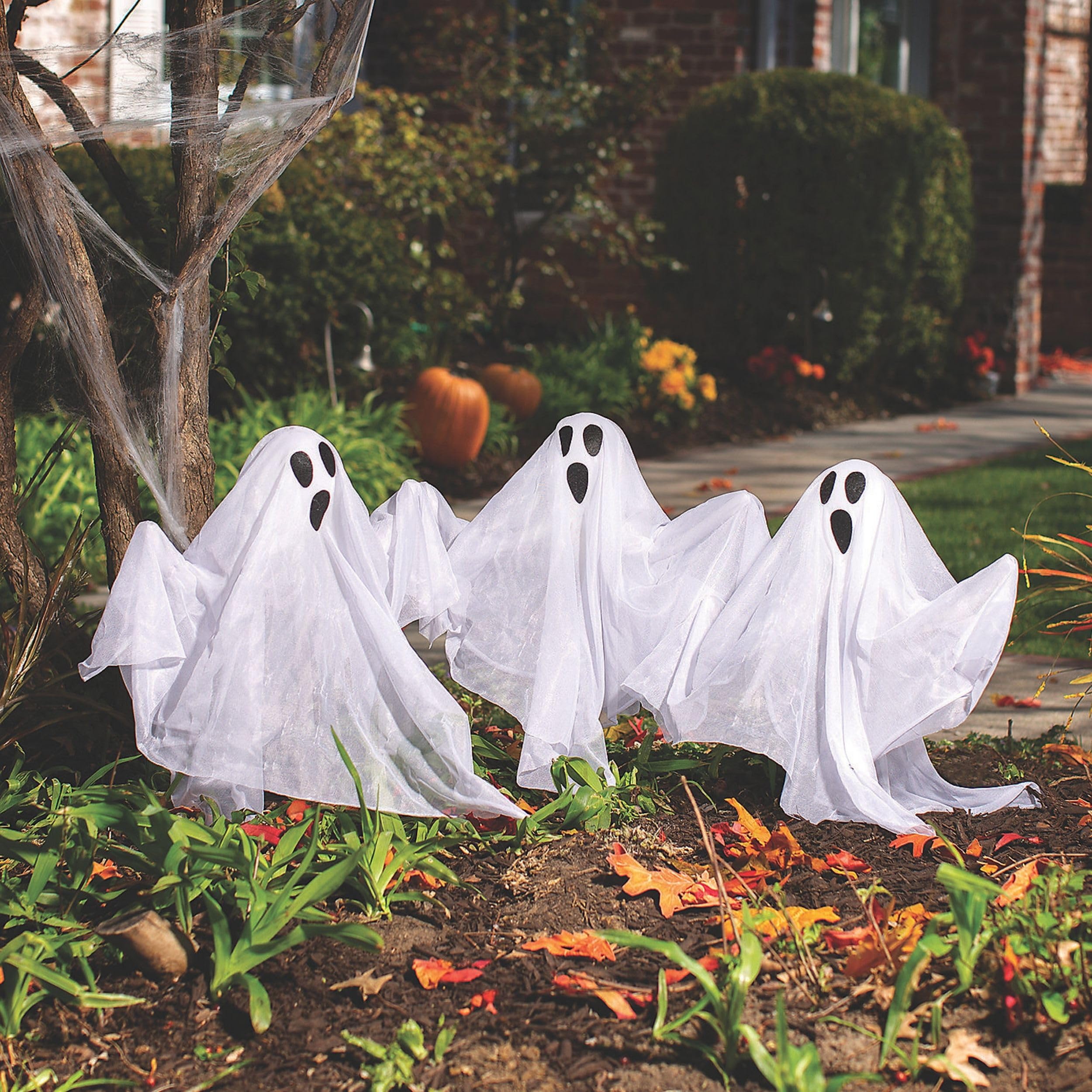 Fun Express yard display at night with ghosts lighting a pathway for safety