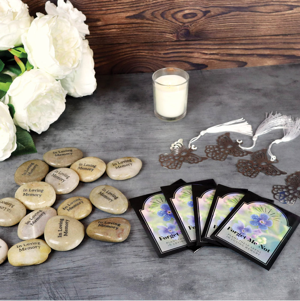 Funeral Favors stones arranged on memorial table with candles to create a respectful setting