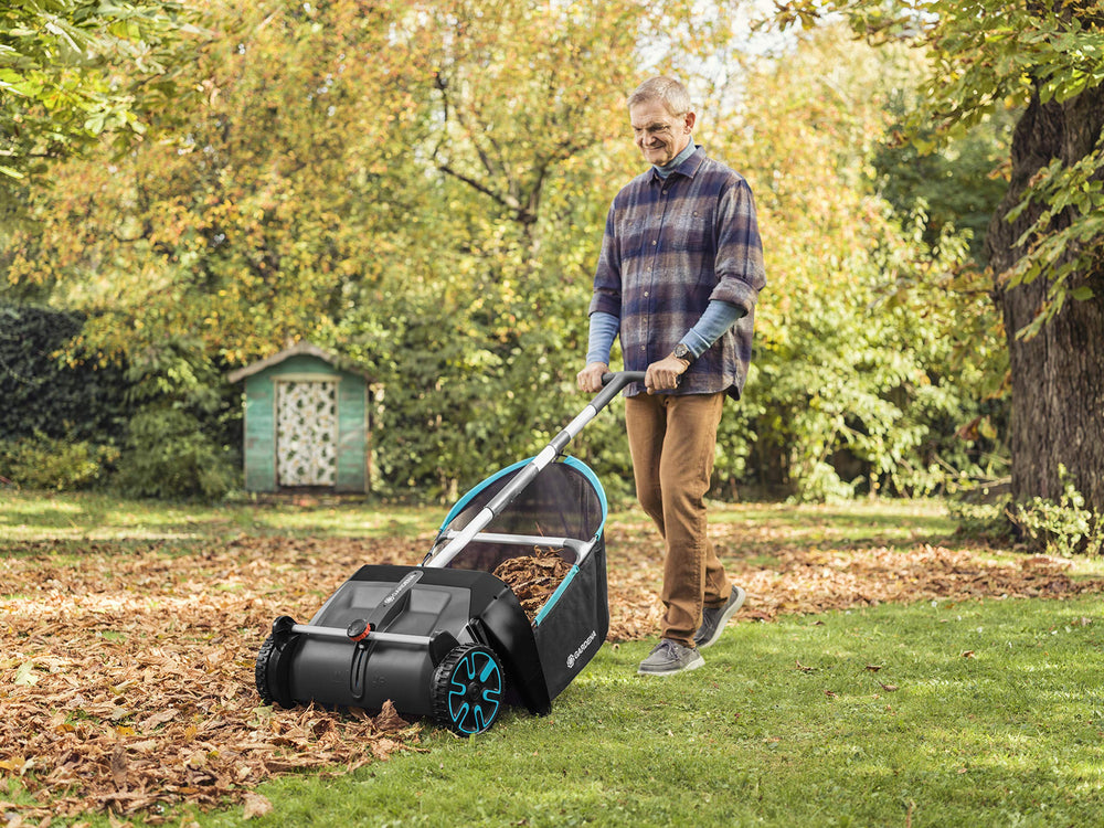 GARDENA sweeper actively collecting leaves on a residential lawn for fast cleanup
