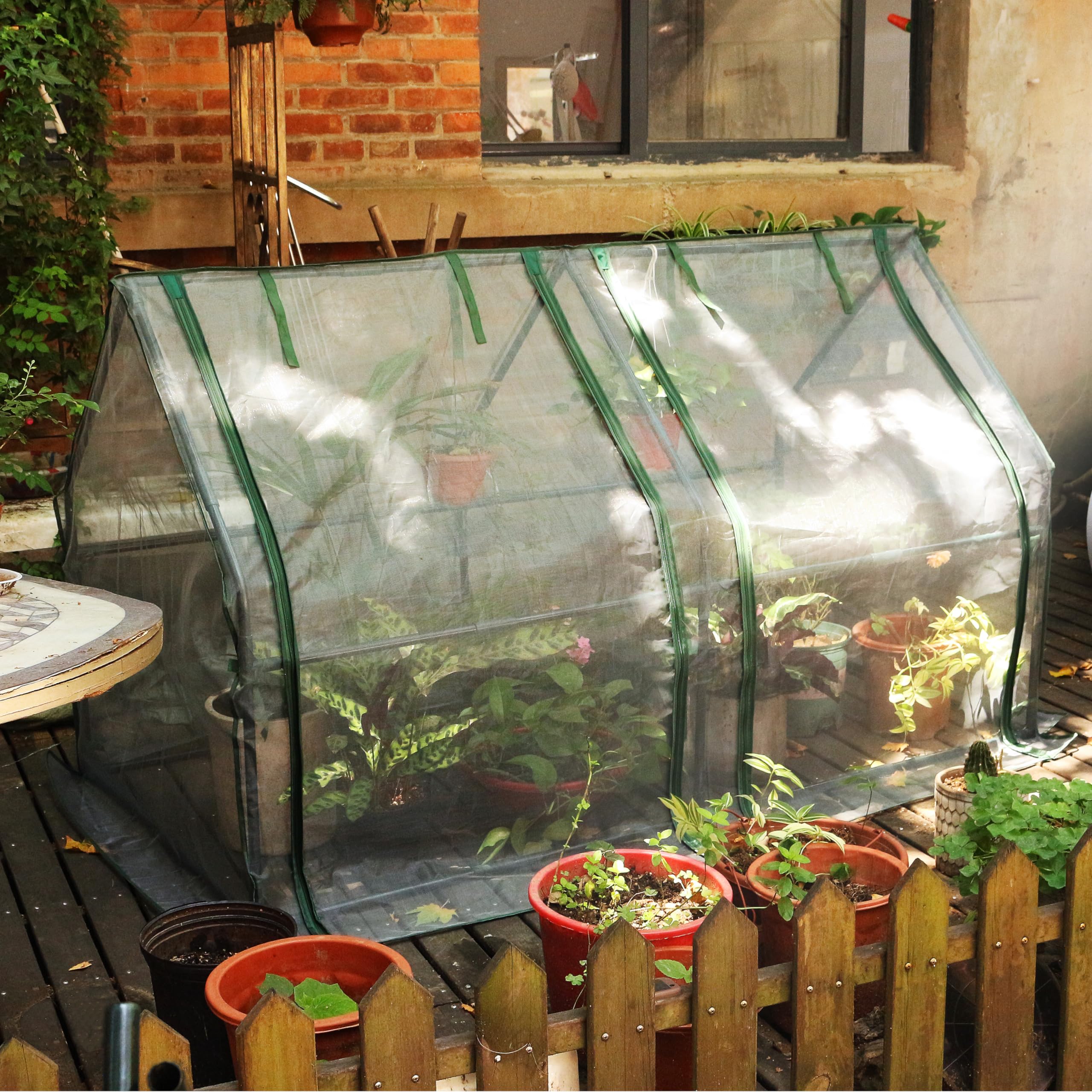 Gardzen beside patio chair to show greenhouse size and placement benefit