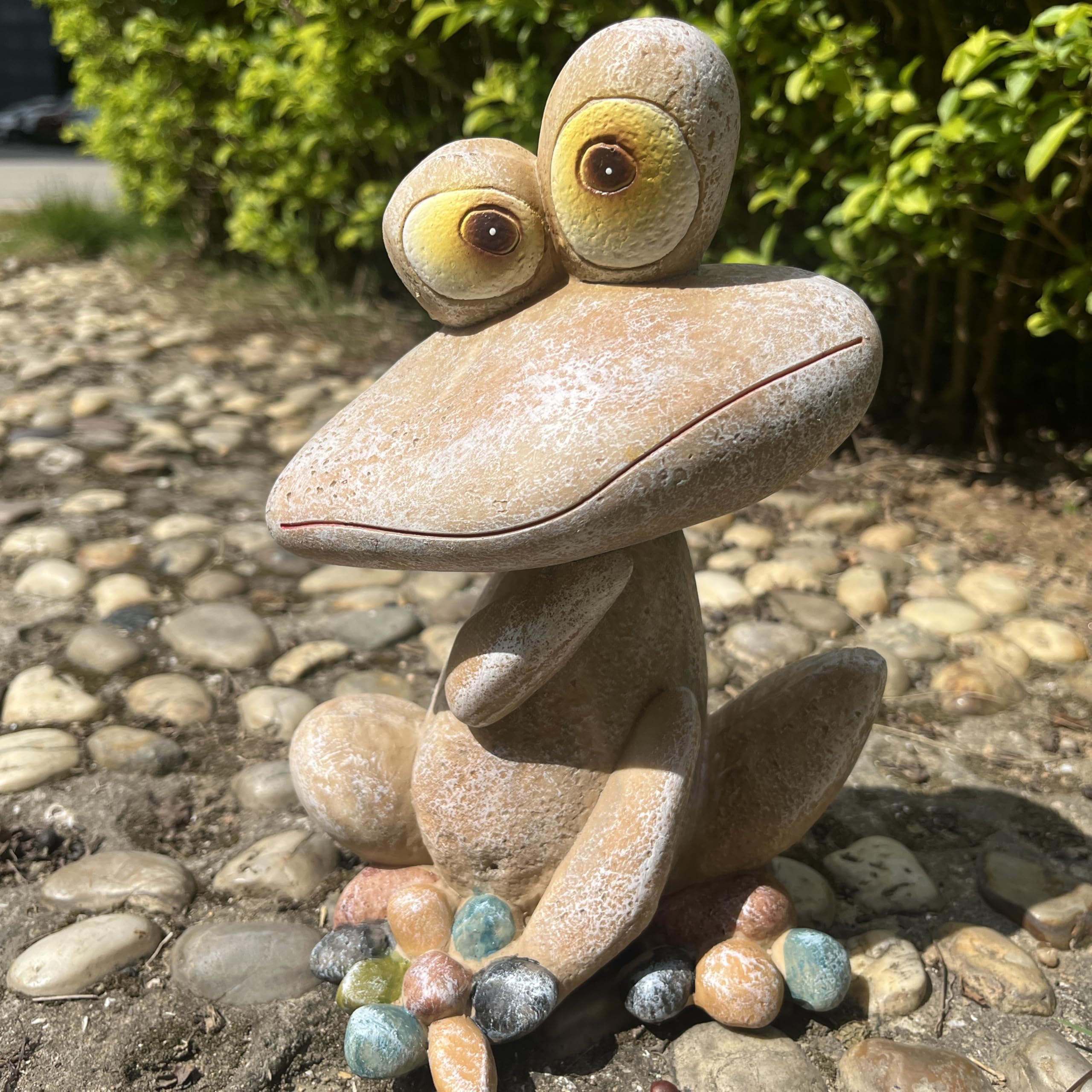 Generic frog nestled in garden bed adding charm to flowers
