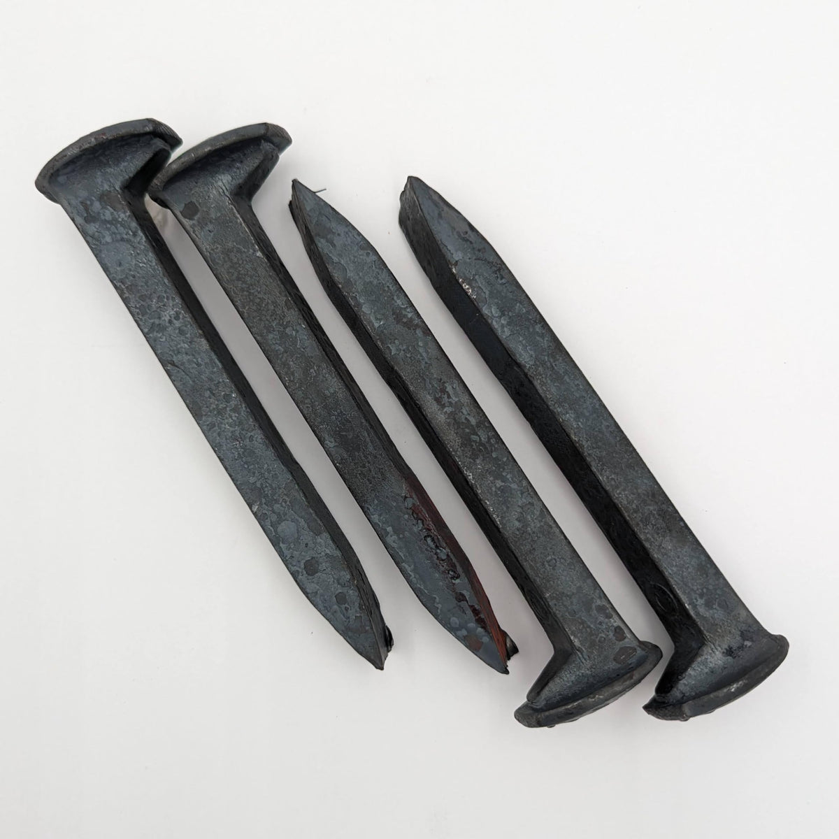 Generic brand front view of four new spikes showing heads and length, useful for crafting
