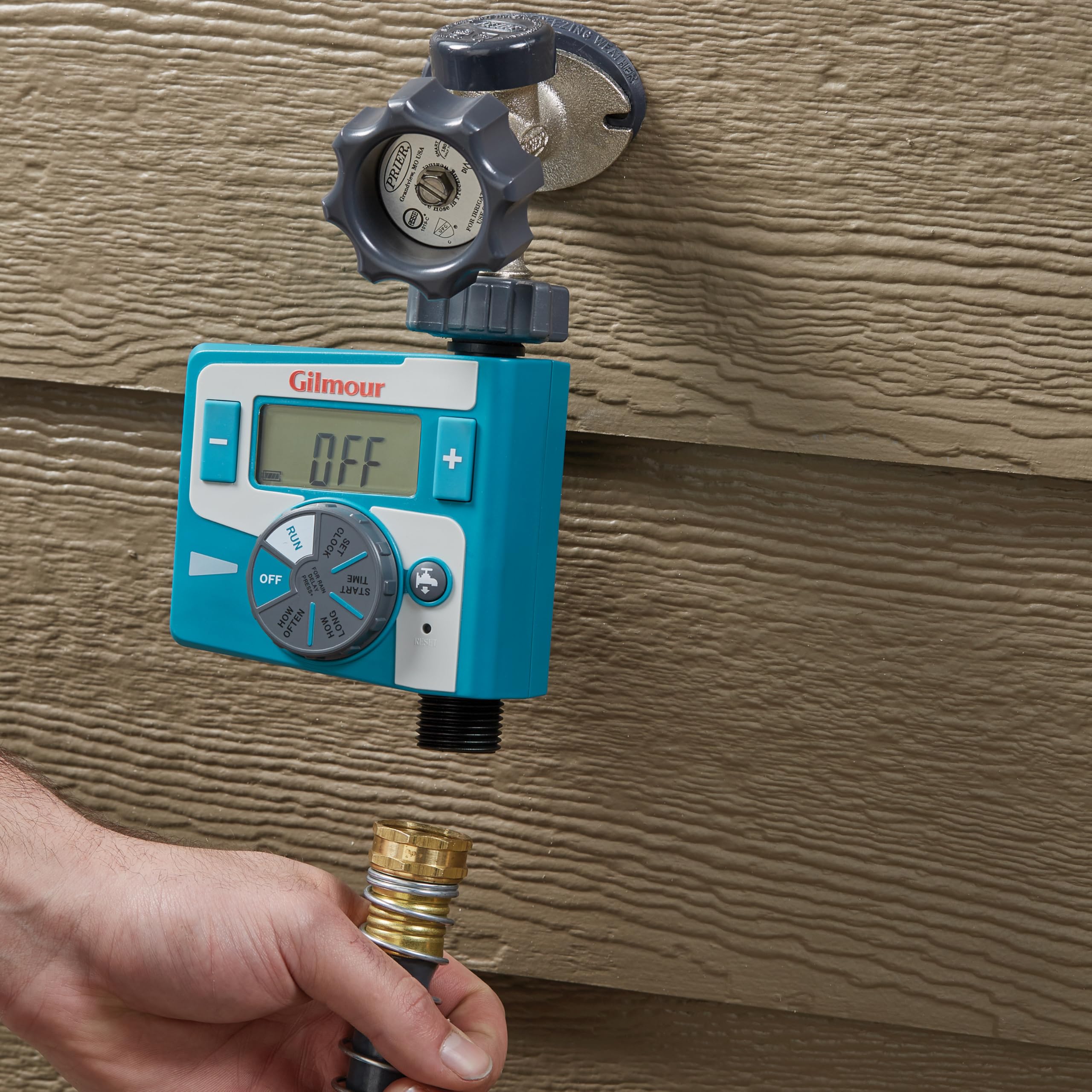 GILMOUR timer attached to hose in garden demonstrating automated watering control