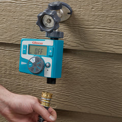 GILMOUR timer attached to hose in garden demonstrating automated watering control