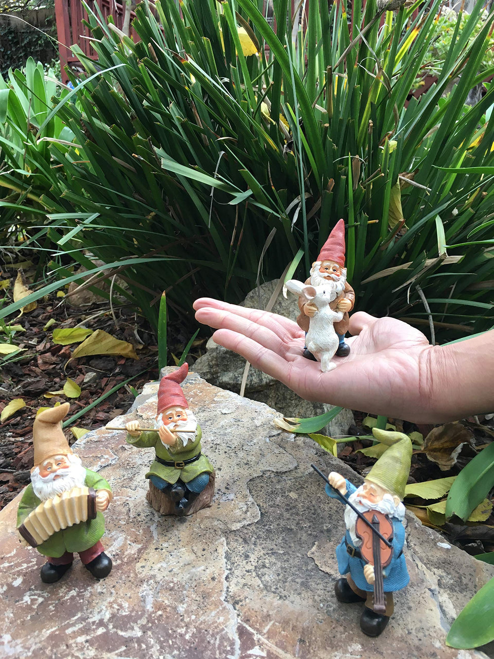 GlitZGlam gnomes arranged in a fairy garden adding whimsical focal point