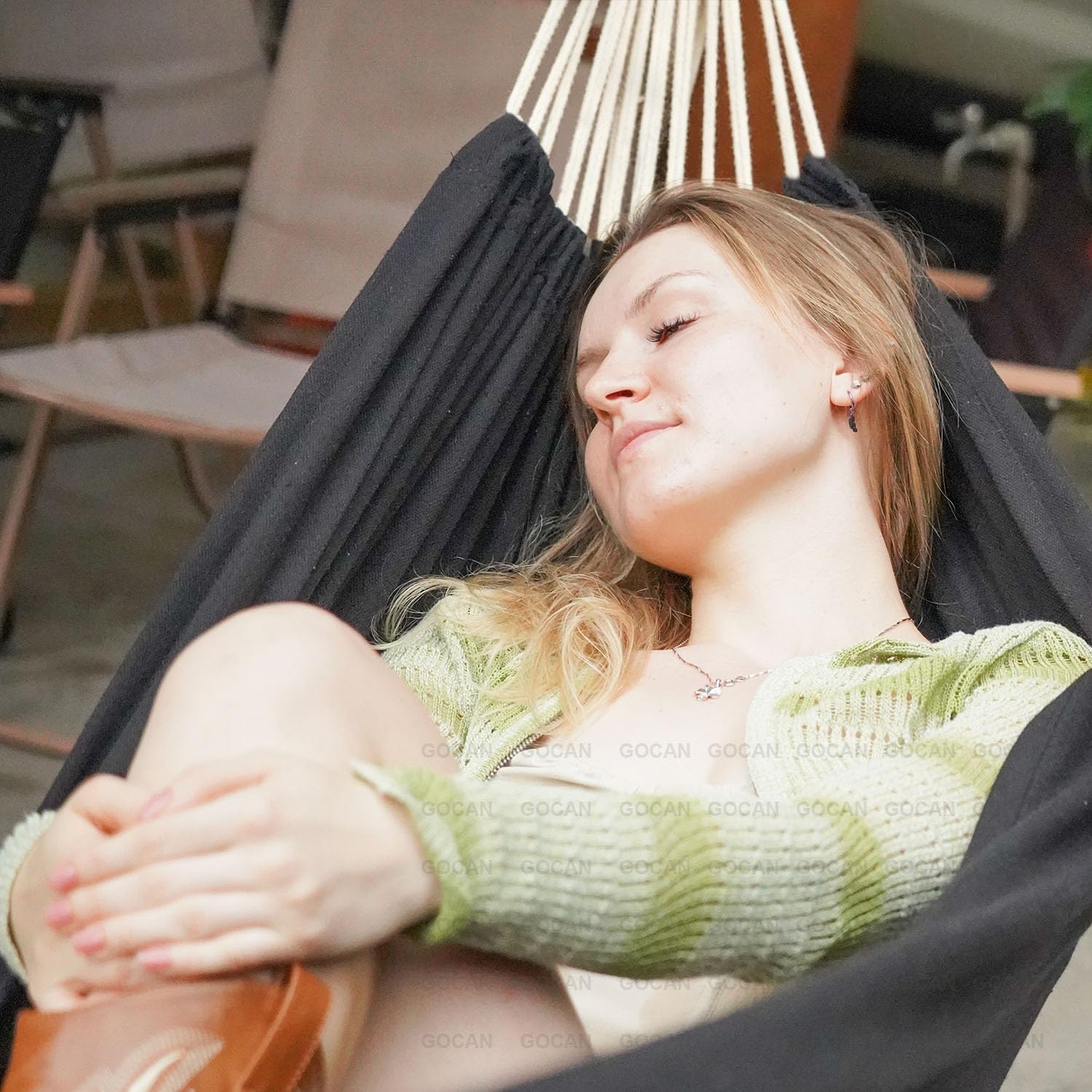 GOCAN hammock on a porch styled with pillows to show lifestyle relaxation