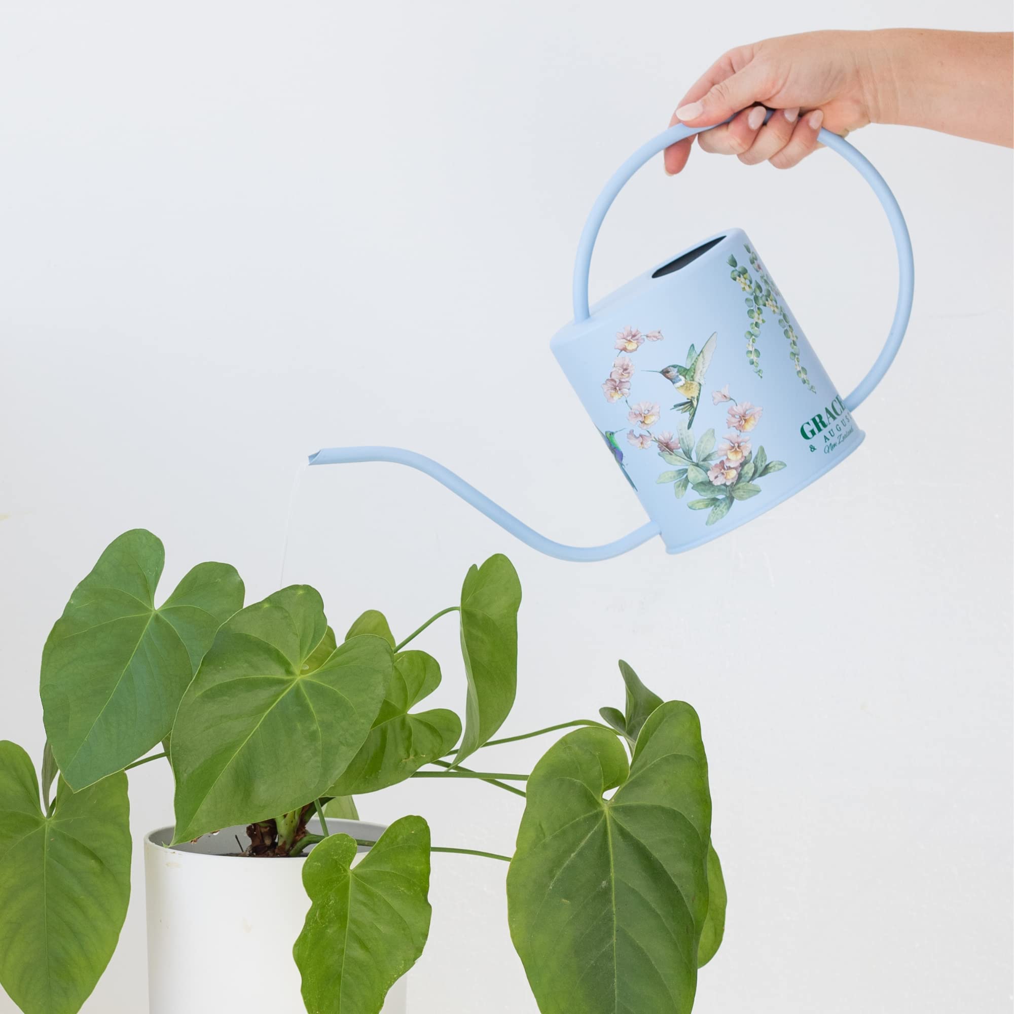Grace and August watering can held in hand showing 1.5L capacity and ergonomic grip