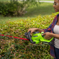Greenworks battery USB port detail charging a phone while trimming outdoors