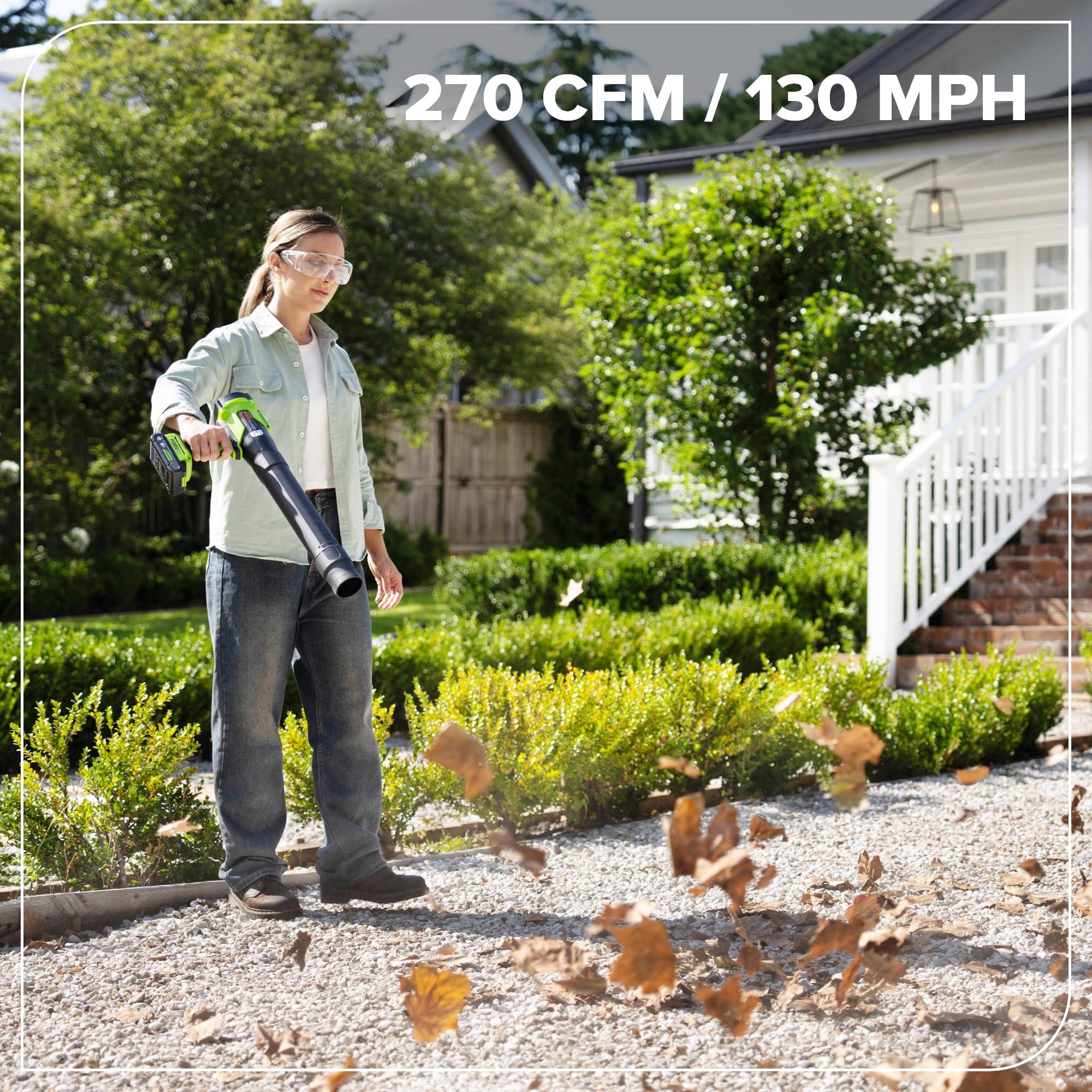 Greenworks blower in use clearing leaves from yard for efficient cleanup benefit