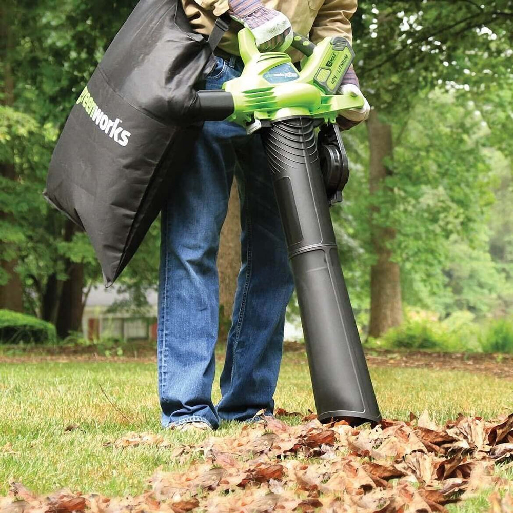 Greenworks blower in use on driveway clearing wet leaves showing powerful performance