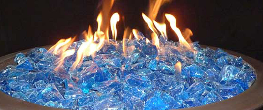 Hiland turquoise fire glass close-up in a fire pit reflecting flame light and depth