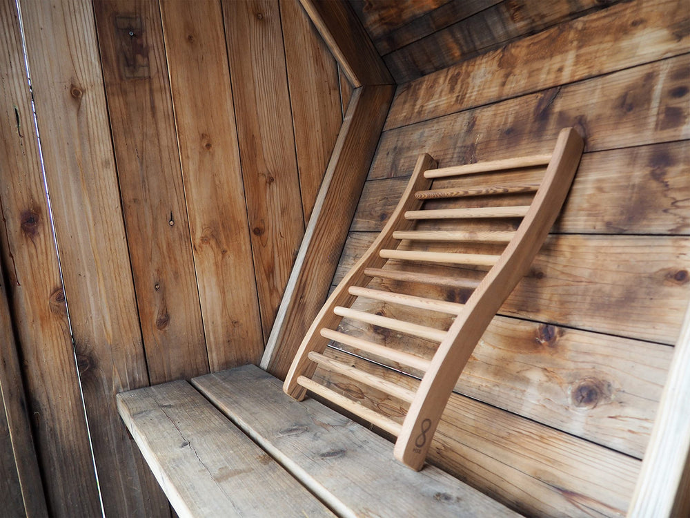 Home Sauna Experience leaning on traditional sauna bench for relaxed posture