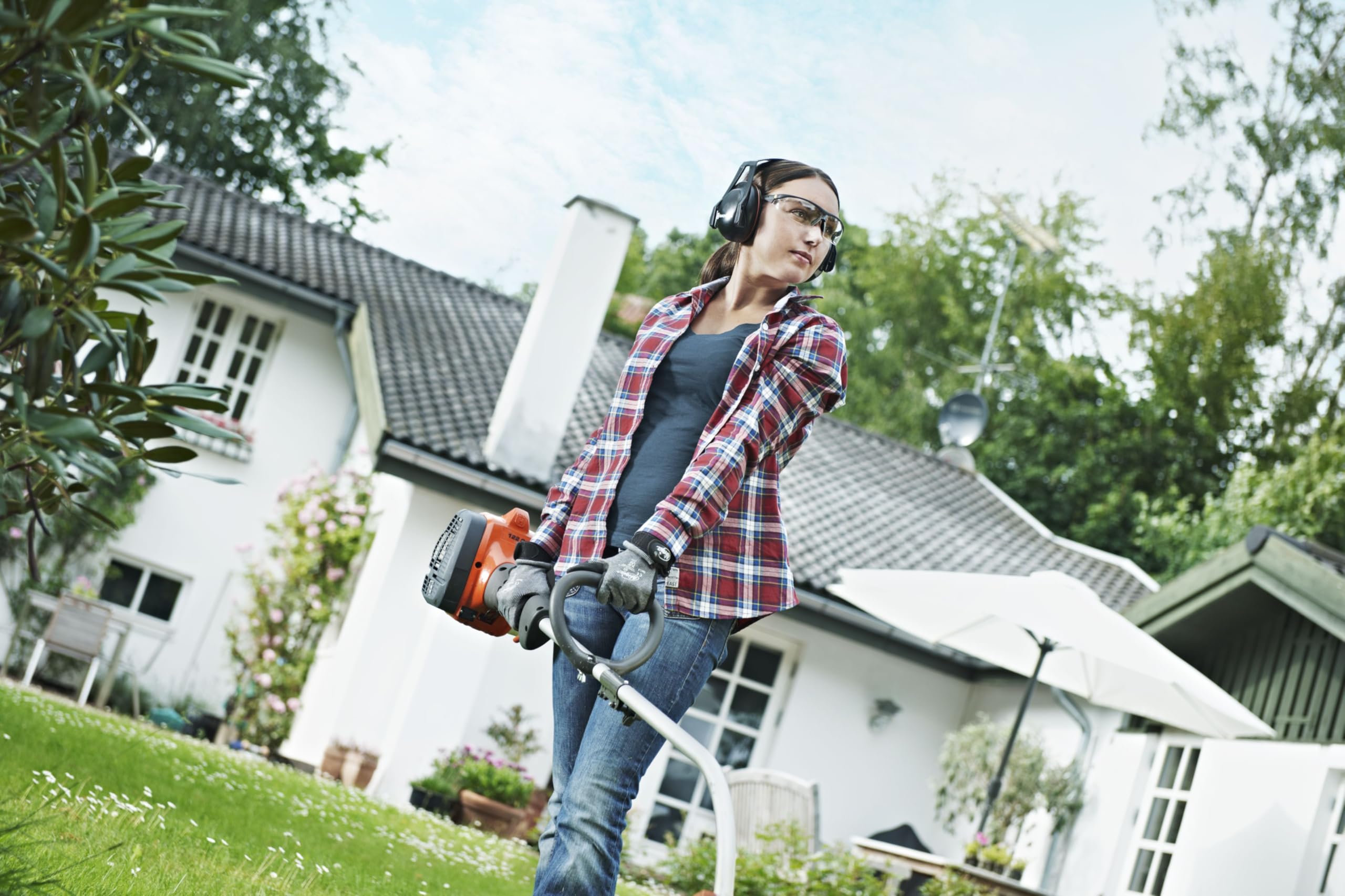 Husqvarna in a suburban yard demonstrating easy obstacle trimming benefit