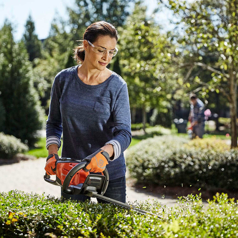 Husqvarna 115iHD55 in a garden setting demonstrating quiet operation and easy residential use