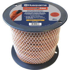 Husqvarna spool held in hand for size comparison showing bulk 3 lb capacity