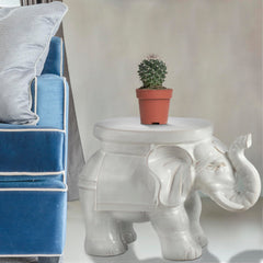 JONATHAN Y elephant stool holding a potted plant to elevate and display greenery