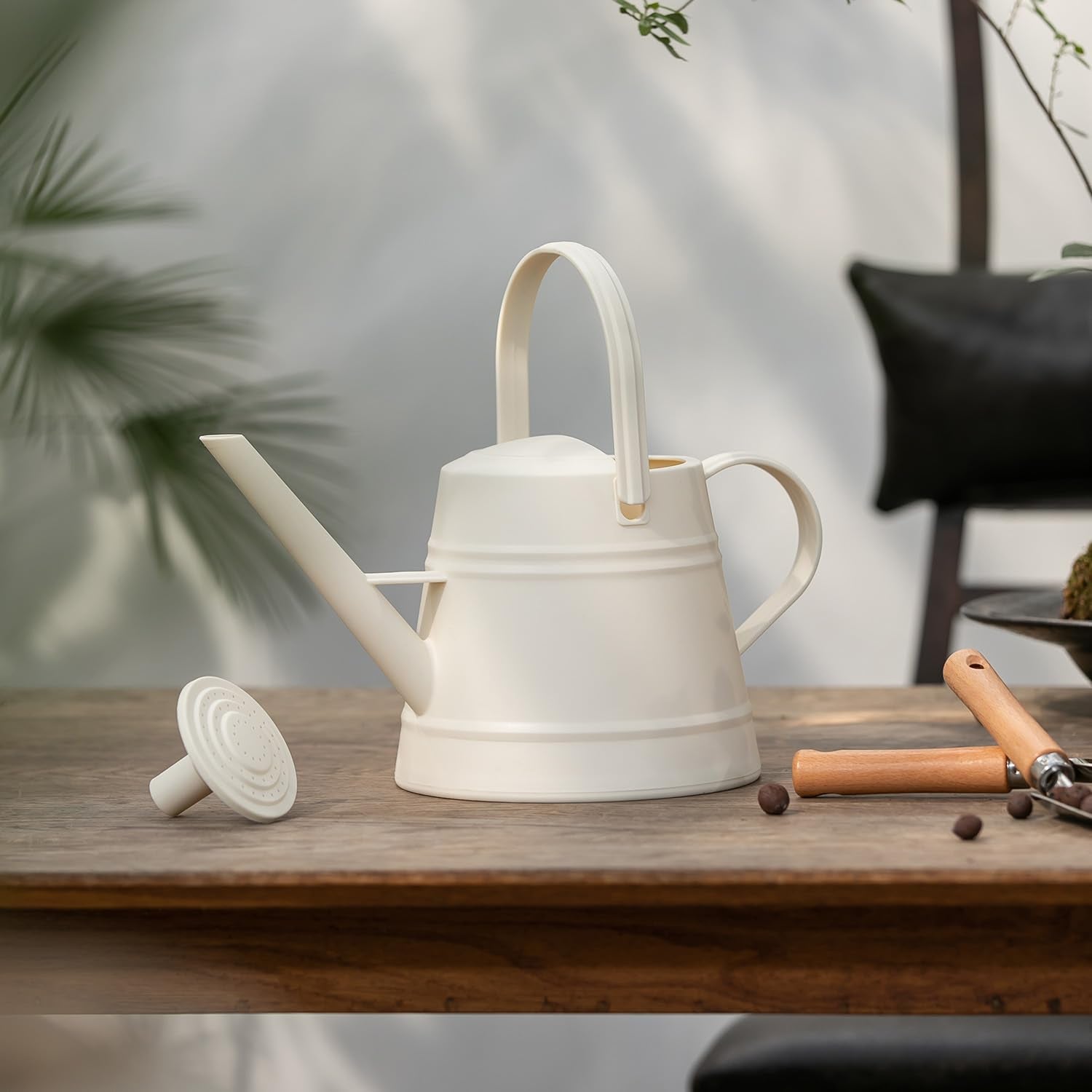 JUSUFU watering can placed on porch with plants showing decorative and practical use