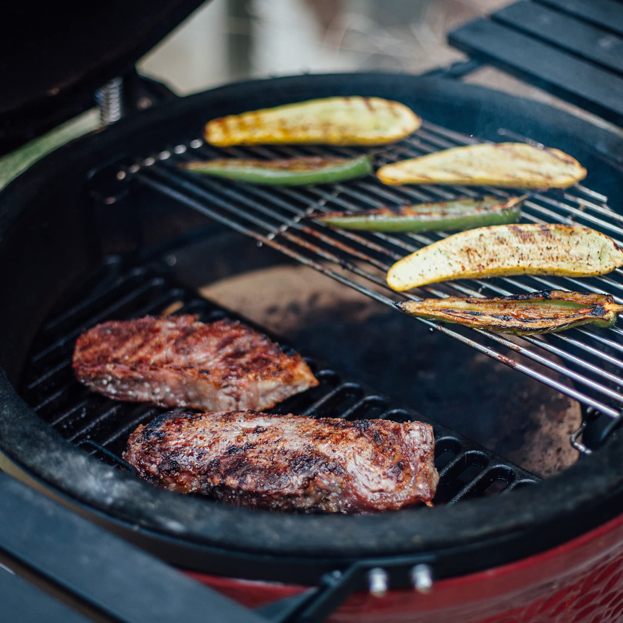 Kamado Joe grate in-use showing dual-level Divide & Conquer flexibility for multi-zone cooking