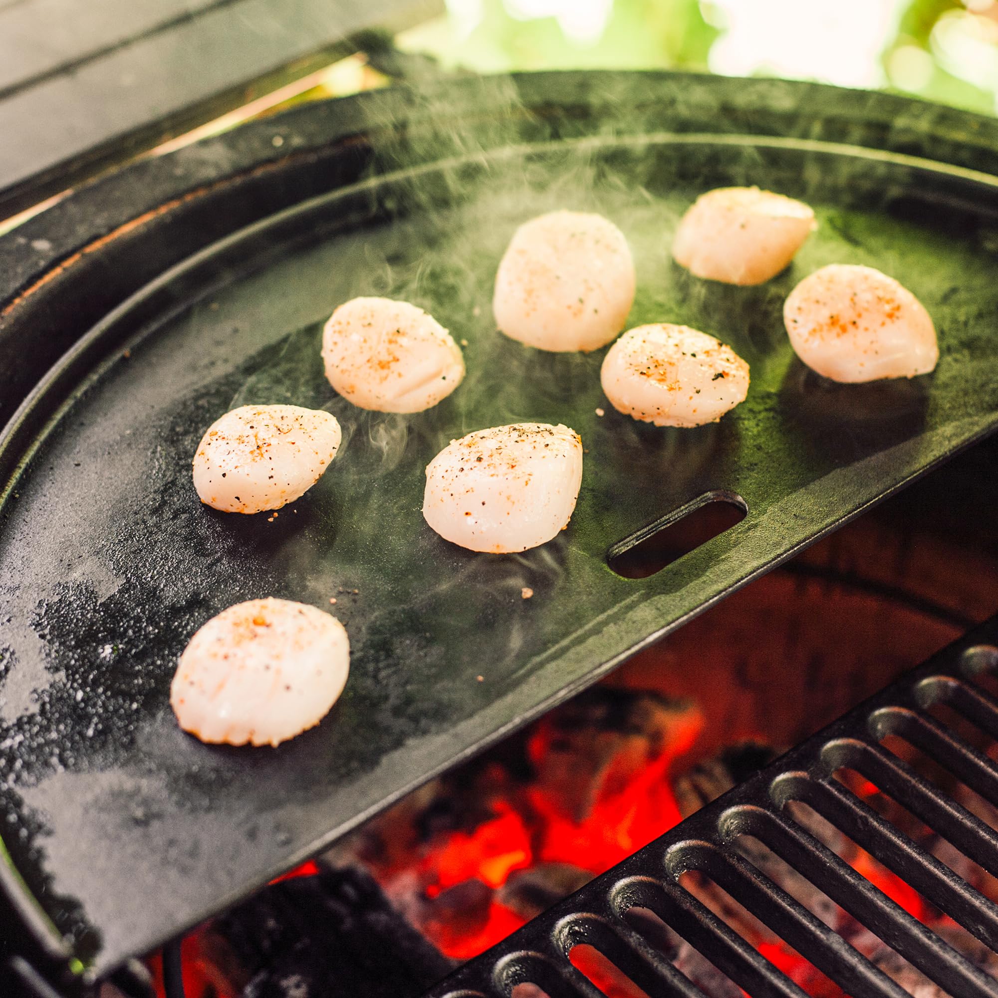 Kamado Joe griddle next to hand for scale showing compact half-moon size