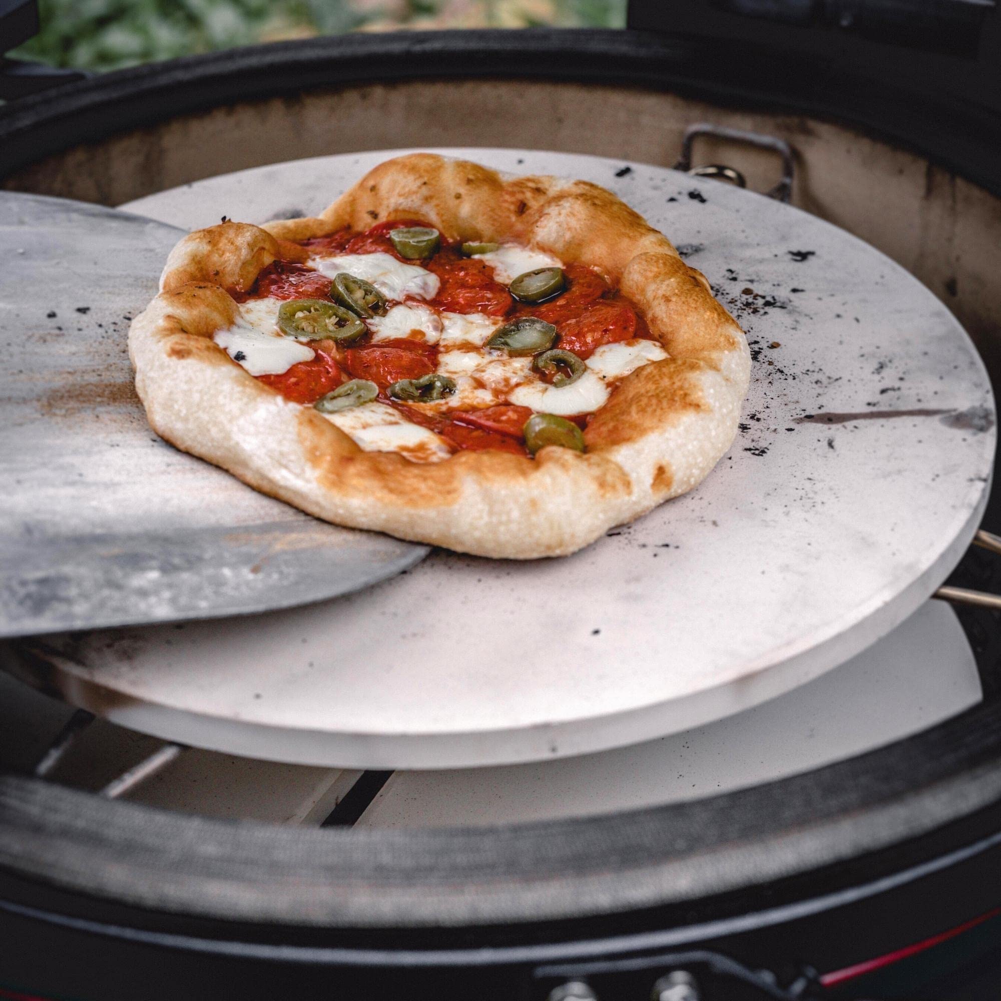 Kamado Joe pizza stone in use with pizza demonstrating crisp crust benefit