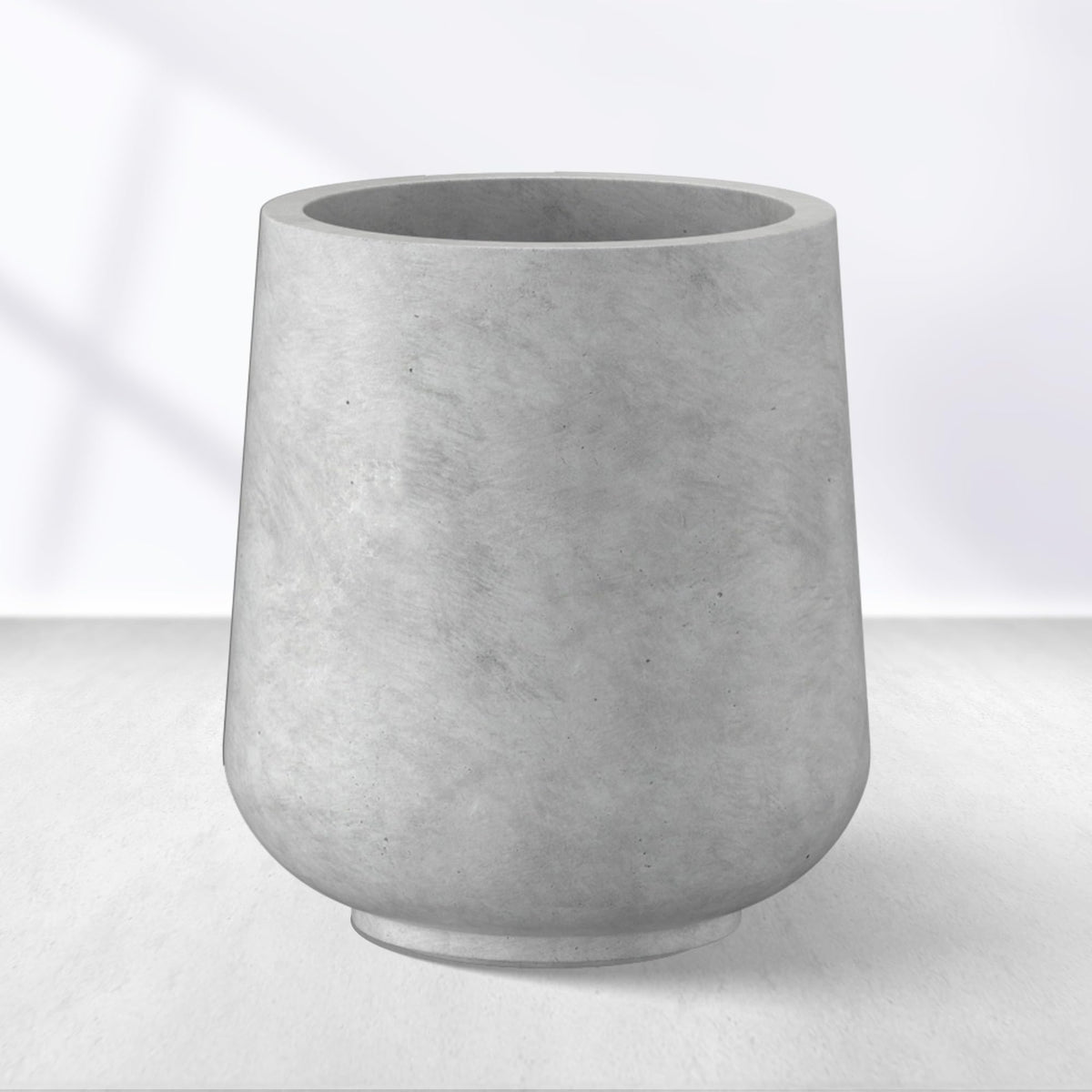 Kante planter front view showing pale gray concrete finish and modern curve, boosts curb appeal