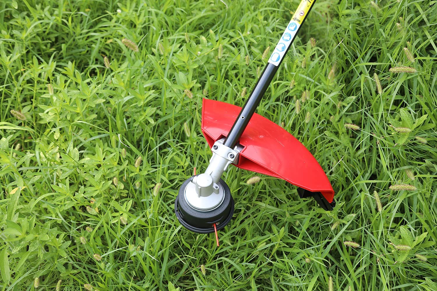 Kerlista attachment connected to a powerhead cutting brush in a backyard for efficient clearing