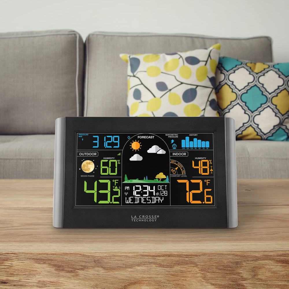 La Crosse Technology held in hand to show size and readable color screen for easy viewing