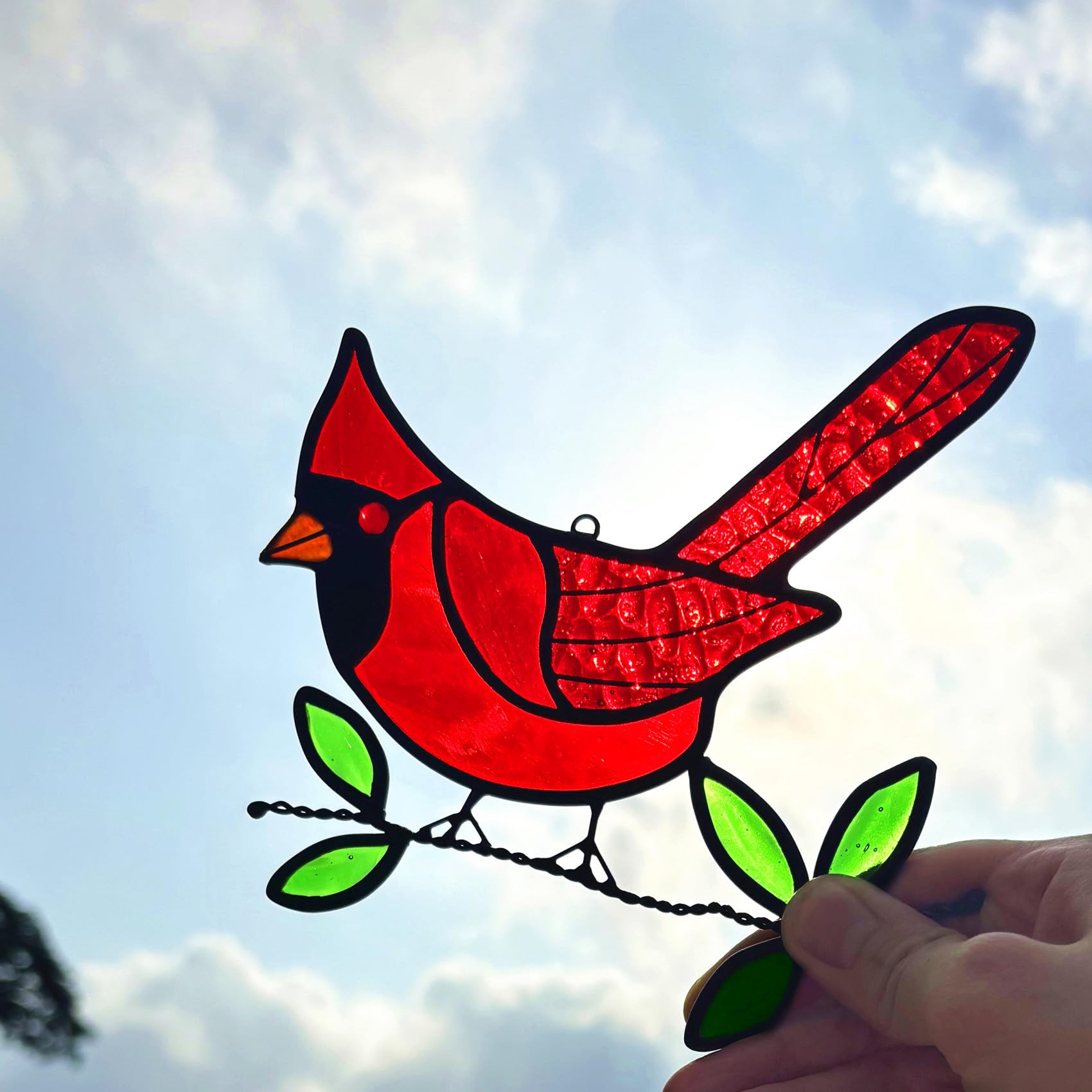 Lcensp suncatcher held in hand to show scale and easy hanging for versatile placement
