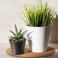 Leinuosen mat under multiple pots on wooden table protecting surface from stains