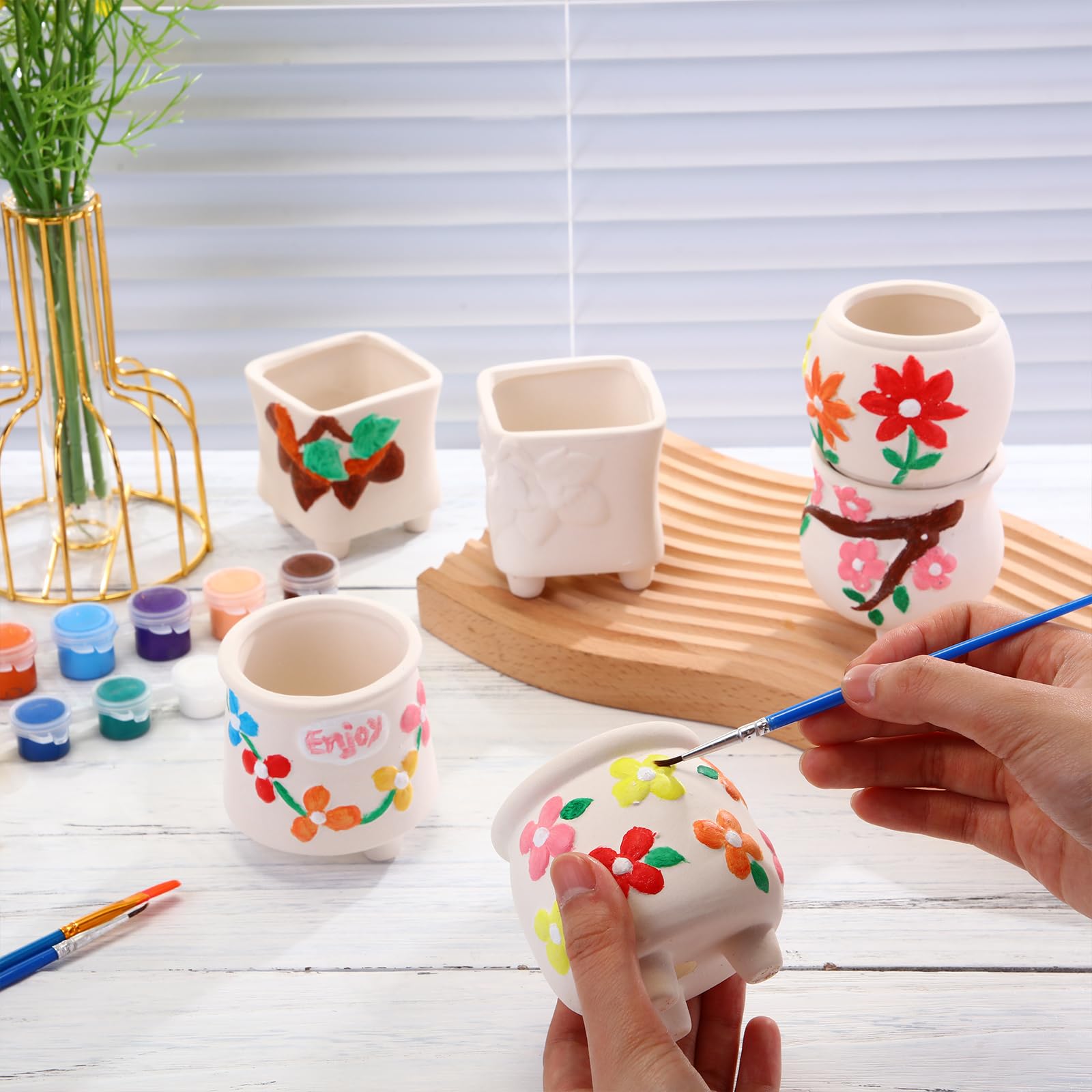 Leitee top-down arrangement of painted and blank pots for inspiration