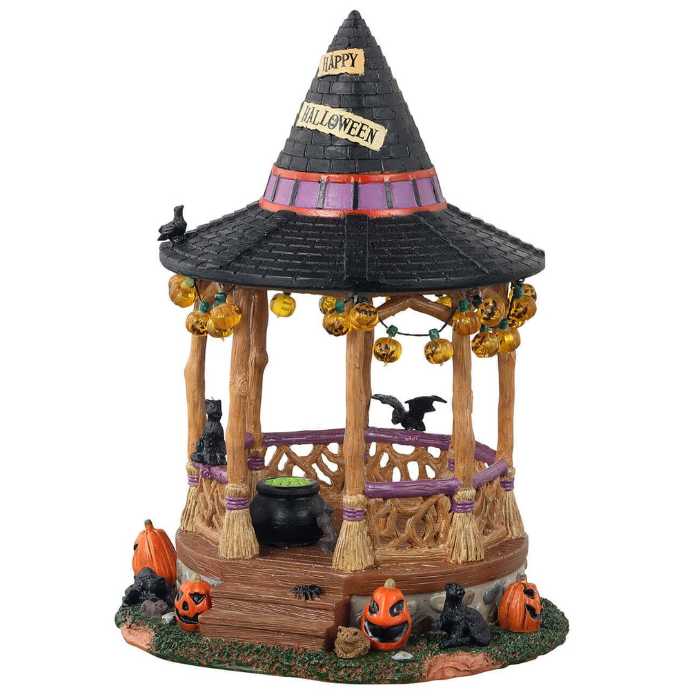 Lemax Witch Gazebo front view showing hat roof and pumpkin lights, adds Halloween charm