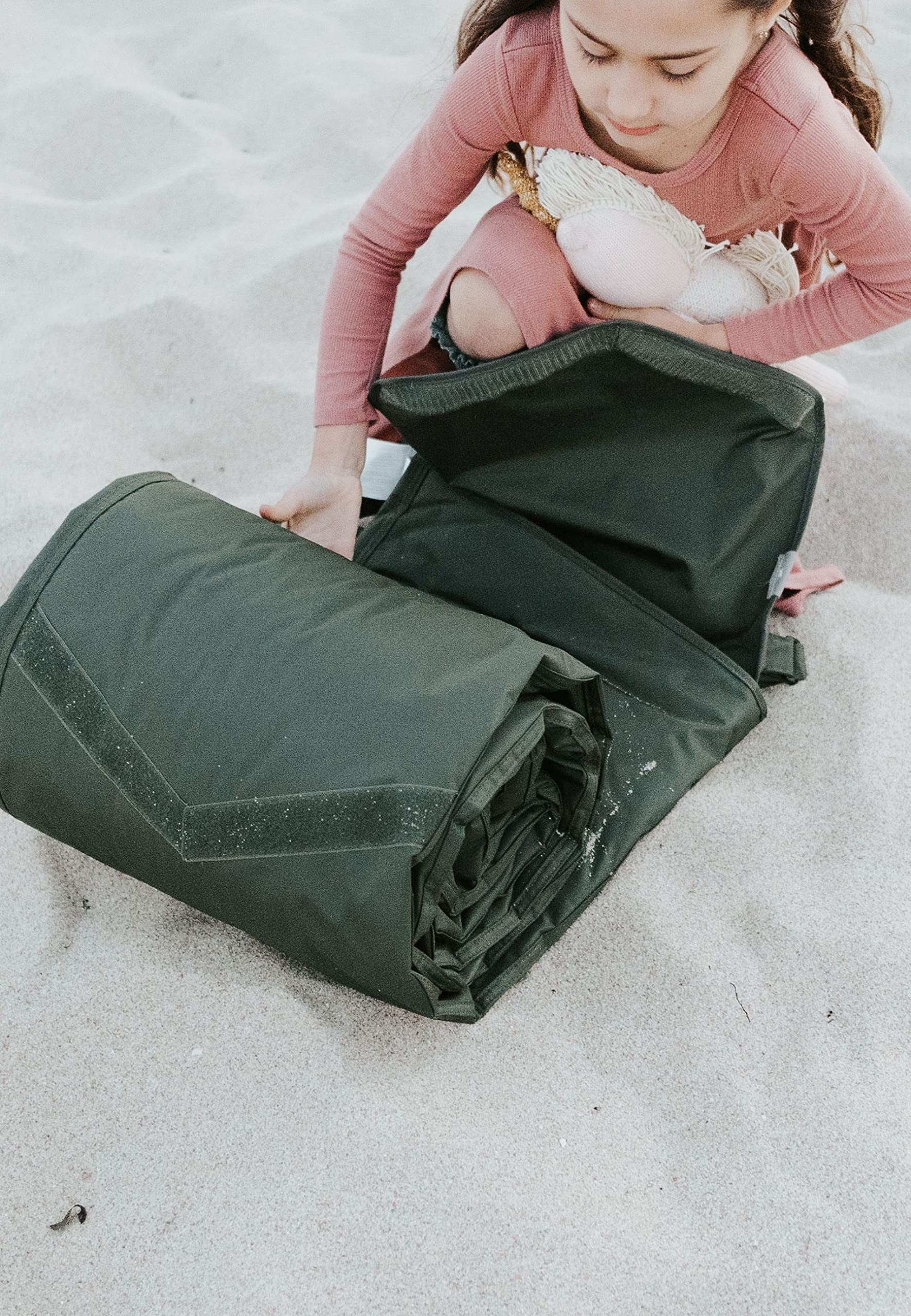 Little Unicorn blanket on beach with family using it showing sand-resistant convenience