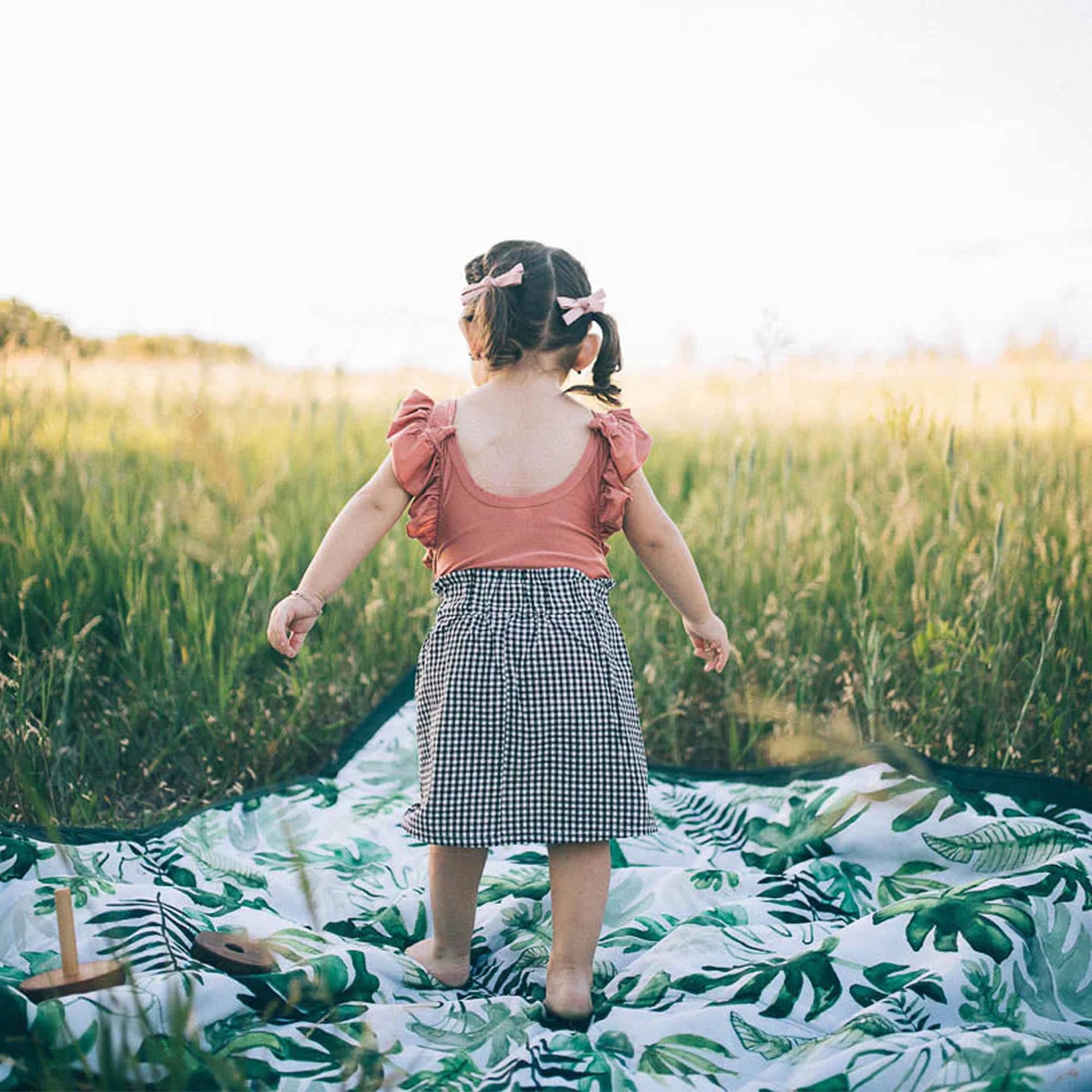 Little Unicorn blanket on beach with family illustrating outdoor comfort benefit