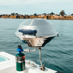 MAGMA grill in use on boat deck demonstrating stable windy-weather cooking performance