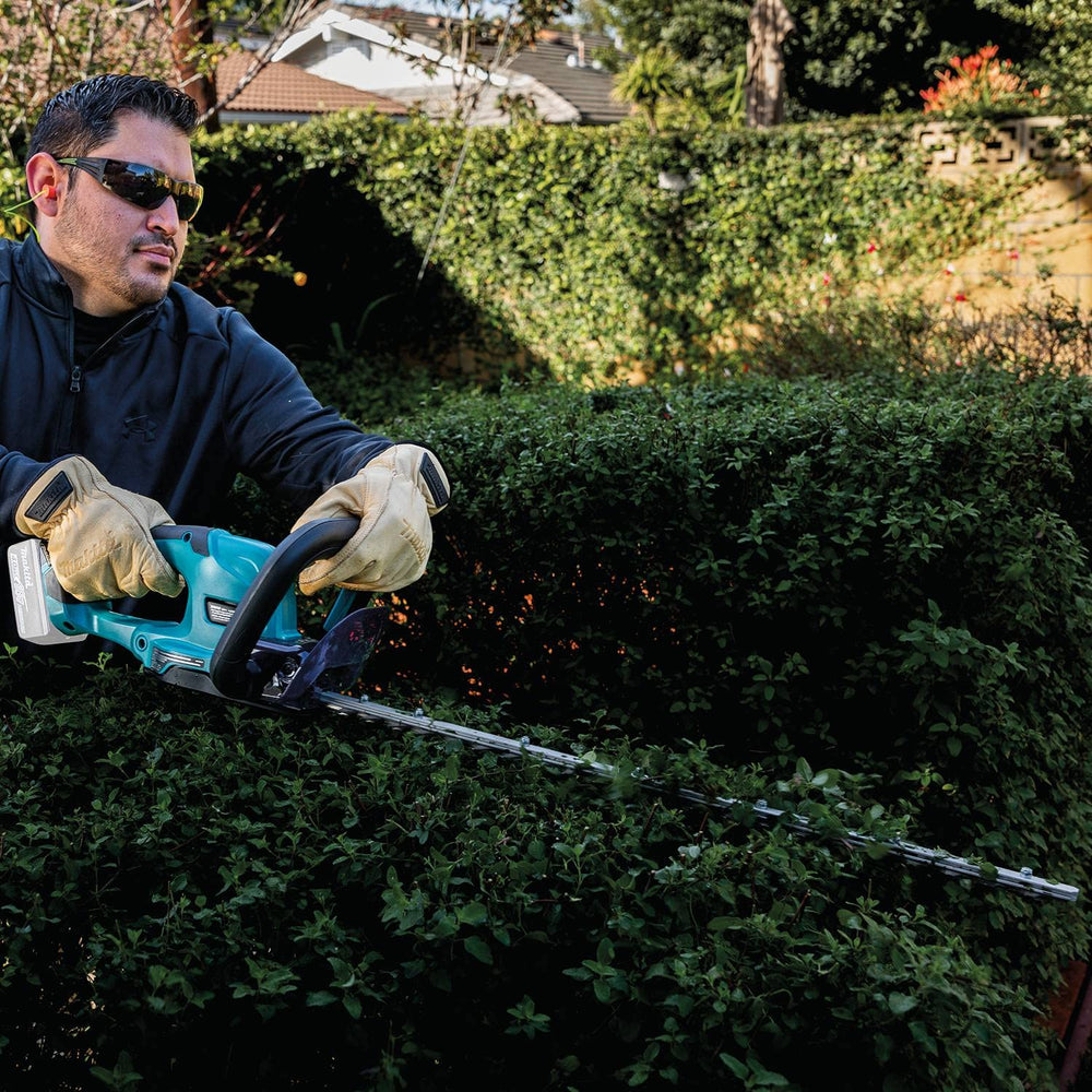 Makita XHU10Z cutting through 3/5-inch branch demonstrating slicing power