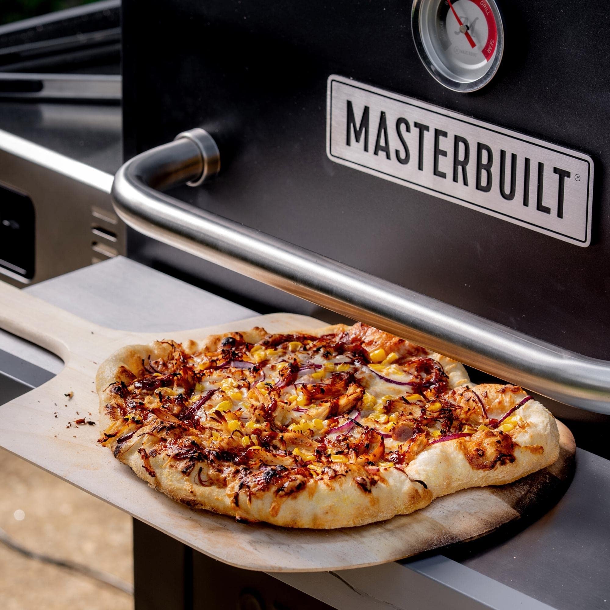 Masterbuilt oven in backyard lifestyle scene showing fast pizza cooking