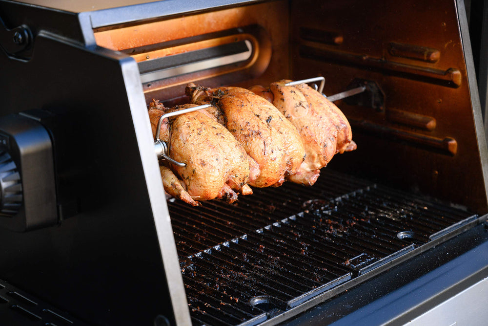 Masterbuilt rotisserie in use with roast turning over charcoal for even browning and flavor