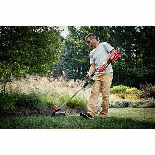Milwaukee trimmer in use cutting overgrown grass to speed yard cleanup