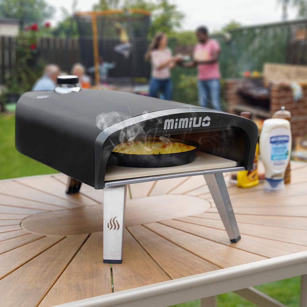 Mimiuo oven next to hand for scale demonstrating portable yet heavy‑duty 33 lb build