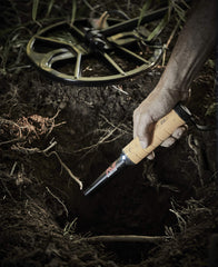 MINELAB PRO-FIND 35 held in hand over sand, demonstrating ergonomic control and quick pinpointing