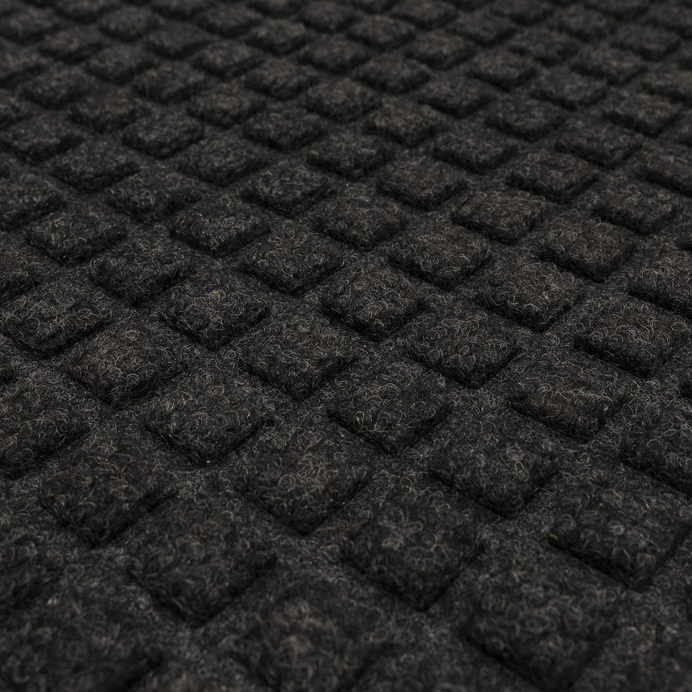 Mohawk Home mat next to foot for scale showing compact 2x3 size and low profile