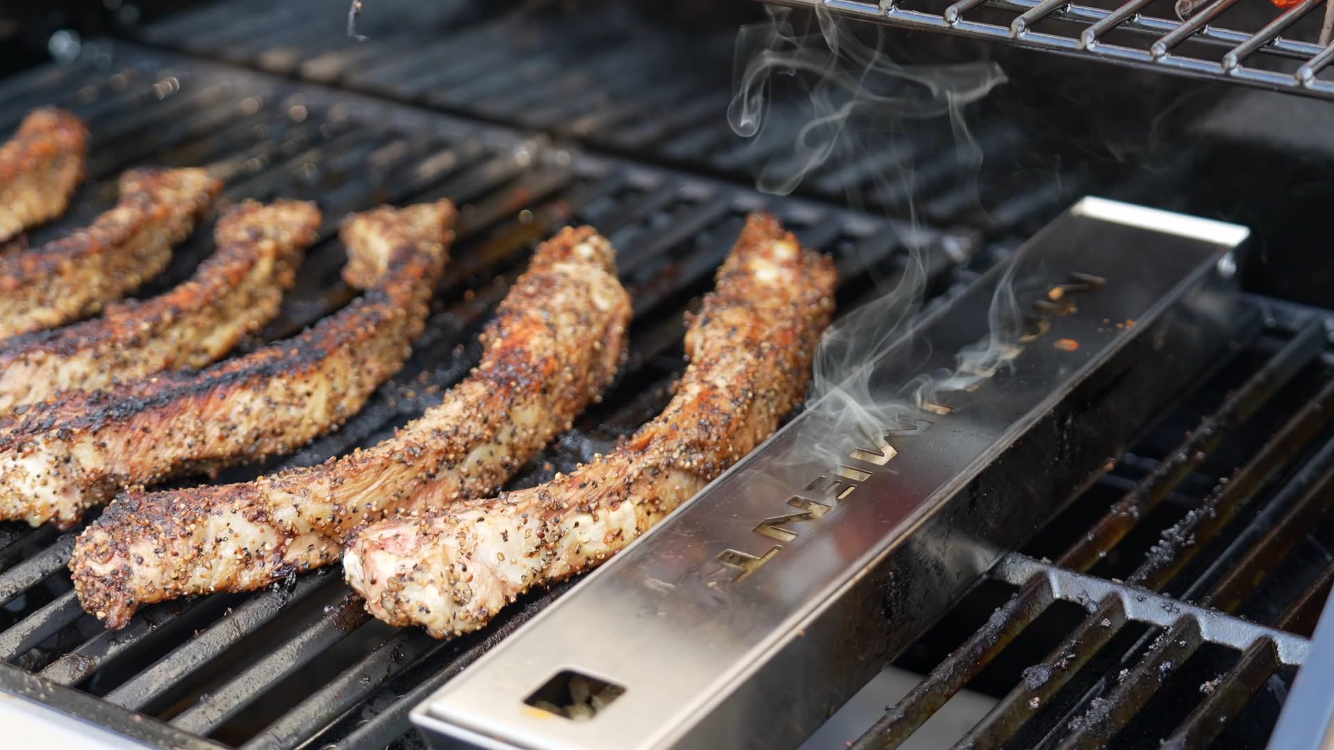 Monument Grills smoker box in backyard setting adding smoke to food for tastier results
