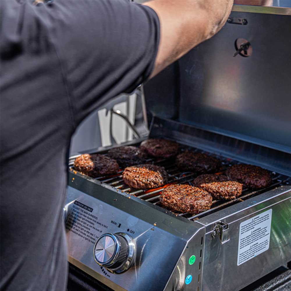 Monument Grills shown next to a hand for scale to demonstrate lightweight 20 lb portability