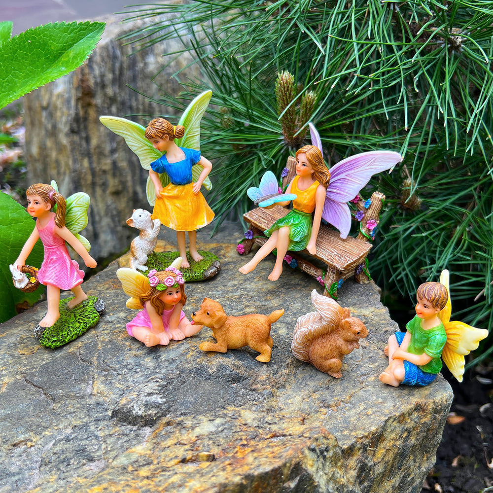 Mood Lab figurines arranged in a potted plant creating a charming miniature garden vignette