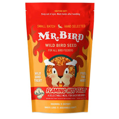 Mr. Bird seed in feeder with colorful bird visiting, attracting cardinals