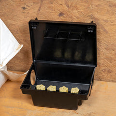 Neogen bait station placed in garage demonstrating concealed, safe baiting