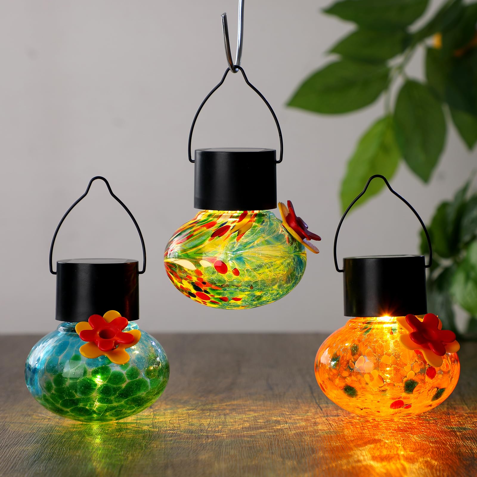Nuogo feeder hanging from a tree branch attracting birds and brightening garden