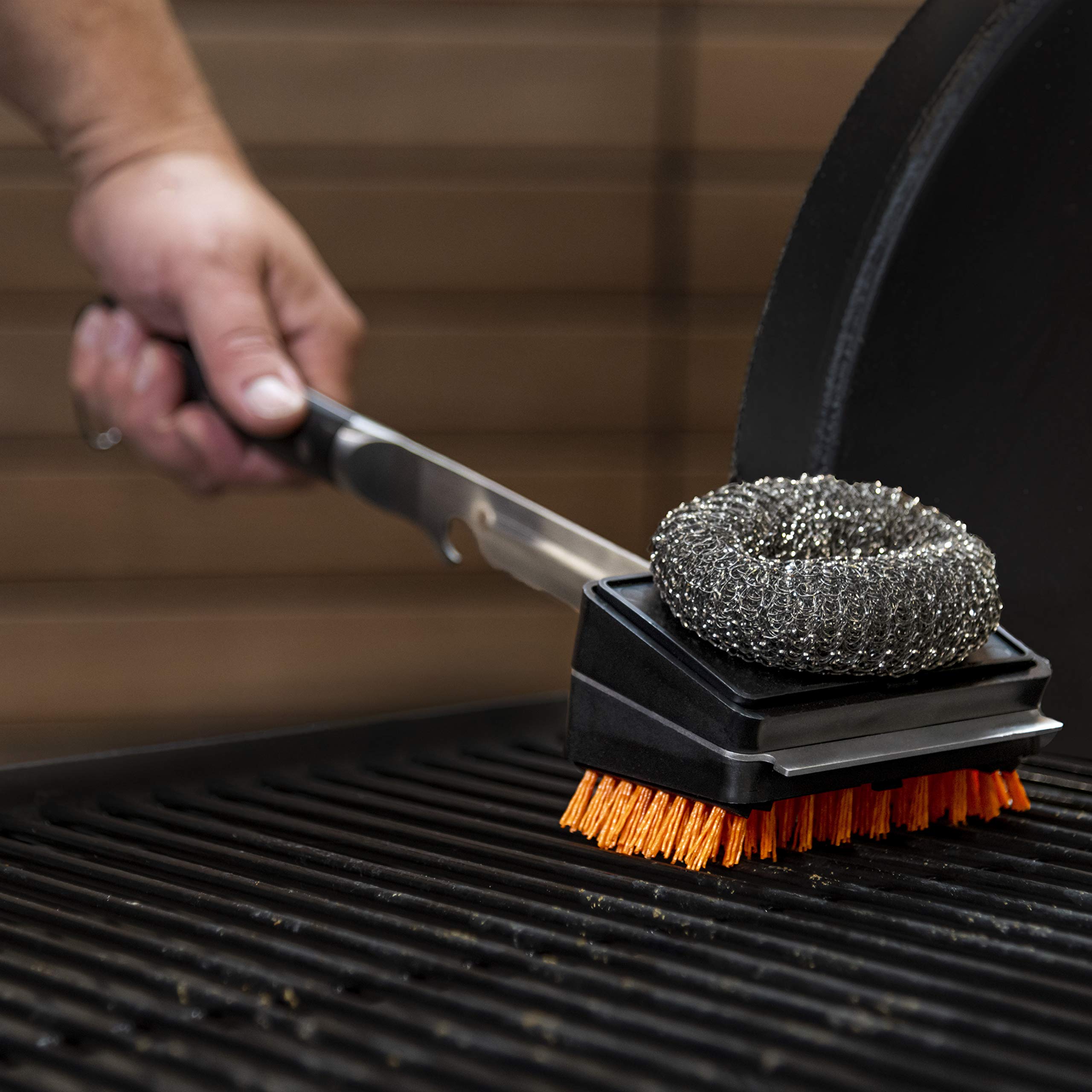 Oklahoma Joe's brush in use on grill grates showing efficient post-cook cleaning